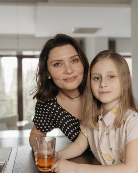 Smiling mother and daughter enjoying quality time in a stylish kitchen.