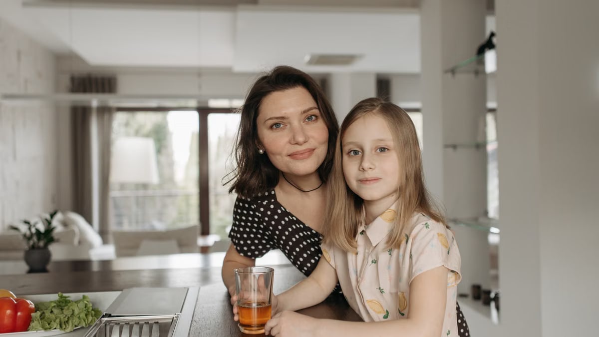 Smiling mother and daughter enjoying quality time in a stylish kitchen.